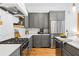 Modern kitchen with stainless steel appliances, gray cabinets, quartz countertops, and a gas range at 10904 Serenbe Ln, Chattahoochee Hills, GA 30268