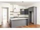 Bright kitchen featuring gray cabinets, a central island, quartz countertops, and modern pendant lights at 10904 Serenbe Ln, Chattahoochee Hills, GA 30268