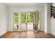 Bright living area featuring hardwood floors, large windows, and views of lush greenery at 10904 Serenbe Ln, Chattahoochee Hills, GA 30268