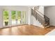 Bright living room with hardwood floors, a staircase, and large windows offering green views at 10904 Serenbe Ln, Chattahoochee Hills, GA 30268