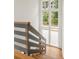 Modern staircase with hardwood treads, stylish railing, and a large window at 10904 Serenbe Ln, Chattahoochee Hills, GA 30268