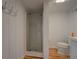 Bathroom featuring an enclosed shower, toilet, and wooden floors at 22 Waters Bridge Cir, Covington, GA 30014