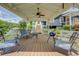 Covered patio features a ceiling fan, outdoor seating, and steps leading up to the main house entrance at 22 Waters Bridge Cir, Covington, GA 30014