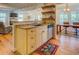 Charming kitchen featuring a tan island, stainless steel appliances, and wooden shelves at 22 Waters Bridge Cir, Covington, GA 30014