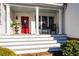 Inviting front porch with white pillars, rocking chair, and a decorative red front door at 255 Maple Nw Ave, Marietta, GA 30064