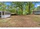 Large, open backyard featuring mature trees and a screened-in porch at 3152 Ridgecrest Dr, Powder Springs, GA 30127