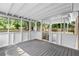 Covered porch with a wood floor, pet door, and screened openings to the backyard at 3152 Ridgecrest Dr, Powder Springs, GA 30127