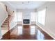 Bright living room boasts gleaming hardwood floors, a cozy fireplace, and an adjacent staircase at 335 Wilma Sw Ct, Atlanta, GA 30331