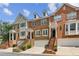 Charming multi-story townhomes featuring brick and stone exteriors, front-facing garages, and landscaped entrances at 3895 Old Atlanta Station Se Dr # 1, Atlanta, GA 30339