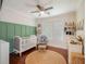 Charming Bedroom with hardwood floors, a crib, a glider, and shelves adorned with decorative accents and a neutral color palette at 265 Haas Se Ave, Atlanta, GA 30316