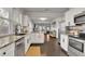Open kitchen with granite countertops, stainless steel appliances, white cabinets, and dark floors flowing into the living area at 265 Haas Se Ave, Atlanta, GA 30316