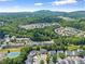 Expansive aerial view showcases the community with green trees, tennis court, and rolling hills at 1628 Indian Way, Cumming, GA 30040