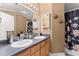 Bathroom featuring double sinks, large mirror, shower with curtain and decorative shelves at 1628 Indian Way, Cumming, GA 30040