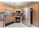 Bright kitchen featuring stainless steel appliances, wooden cabinets, and white tiled floor at 1628 Indian Way, Cumming, GA 30040