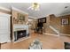 Elegant living room with hardwood floors, a fireplace, stylish sofas, and a staircase at 1628 Indian Way, Cumming, GA 30040