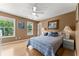 Well-lit main bedroom featuring hardwood floors, two bedside tables, and two windows with outdoor views at 1628 Indian Way, Cumming, GA 30040