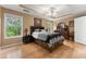 Main bedroom featuring decorative tray ceiling, wood floors, large windows and a dresser at 1628 Indian Way, Cumming, GA 30040