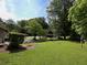 View of expansive backyard with lush greenery, carport, and mature trees at 286 Sequoia Ne Dr, Marietta, GA 30060