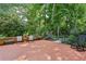 This back patio has brick flooring with beautiful landscaping and outdoor furniture at 302 Ridley Howard Ct # 302, Decatur, GA 30030