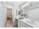 Bright bathroom featuring a long vanity, decorative mirror, and a glimpse into an adjacent bedroom at 302 Ridley Howard Ct # 302, Decatur, GA 30030