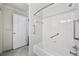 Tiled bathroom featuring a shower/tub combination with safety bars and an open doorway at 302 Ridley Howard Ct # 302, Decatur, GA 30030
