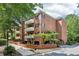 Brick condo building with white balconies, black shutters, and lush green landscaping at 302 Ridley Howard Ct # 302, Decatur, GA 30030