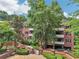 Exterior view of a brick apartment building with a landscaped courtyard and mature trees at 302 Ridley Howard Ct # 302, Decatur, GA 30030