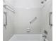 Clean, white tiled shower stall with updated fixtures and grab bars for convenience at 302 Ridley Howard Ct # 302, Decatur, GA 30030