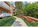 Exterior walkway featuring a brick wall and mature landscaping in a beautiful community at 302 Ridley Howard Ct # 302, Decatur, GA 30030