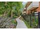 Charming exterior walkway with mature landscaping and black metal decorative fencing at 302 Ridley Howard Ct # 302, Decatur, GA 30030