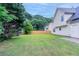 Expansive backyard with green lawn, trees, and partial view of the home’s exterior, offering a private outdoor space at 6181 E Fayetteville Dr, Riverdale, GA 30296