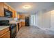Well-lit kitchen features wood cabinets, black appliances, and easy-to-clean tile floors at 6181 E Fayetteville Dr, Riverdale, GA 30296
