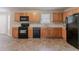 Functional kitchen featuring wood cabinets, black appliances, and ample counter space at 6181 E Fayetteville Dr, Riverdale, GA 30296