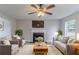 Cozy living room featuring a fireplace, plush seating, a ceiling fan, and bright, neutral decor at 6181 E Fayetteville Dr, Riverdale, GA 30296