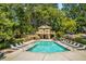 Community pool featuring comfortable lounge chairs, shade trees, and a covered pool house at 1404 N Crossing Ne Dr, Atlanta, GA 30329