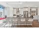 Modern kitchen with a large island featuring a tile backsplash and seating for four at 1621 Wellborn Walk, Suwanee, GA 30024