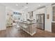 Bright open kitchen with stainless steel appliances, bar stool seating at the island, and a wine refrigerator at 1621 Wellborn Walk, Suwanee, GA 30024