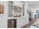 Kitchenette with wine cooler, glassware, storage shelves, and hardwood floors at 1621 Wellborn Walk, Suwanee, GA 30024