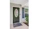 Entryway with a secure, dark-painted door, welcome mat, oval glass and sidelight to the right of the house at 5706 Forest Pl, Acworth, GA 30102