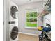 Convenient laundry room features stacked washer and dryer with backyard window views at 5706 Forest Pl, Acworth, GA 30102