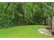 Grassy backyard showcasing lush green lawn, trees, and brick fencing at 1605 Saint Tropez Way, Atlanta, GA 30350