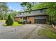 Exterior shot of home showing an attached garage and tree lined driveway at 1605 Saint Tropez Way, Atlanta, GA 30350