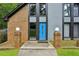 Close up of a home's exterior with a bright blue front door and stylish brick accents at 1605 Saint Tropez Way, Atlanta, GA 30350