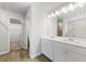 Bathroom with double sink vanity, large mirror, and wood look floors at 2058 Brookhill Way, Snellville, GA 30078
