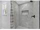 Beautifully tiled shower with a built-in niche, black fixtures, a window, and a shower curtain at 144 Cathy Ln, Hiram, GA 30141