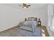 Cozy bedroom featuring a ceiling fan, hardwood floors, and a comfortable queen-sized bed with a gray coverlet at 144 Cathy Ln, Hiram, GA 30141