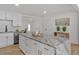Bright kitchen featuring white cabinets with gold hardware and a large island with marble countertops at 144 Cathy Ln, Hiram, GA 30141