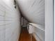 Attic space featuring wood paneling, hardwood floors, and a built-in wire shelving unit at 407 E College E St, Bowdon, GA 30108