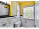 Bathroom featuring vintage tiling, a classic sink, natural light, and a wall mounted cabinet at 407 E College E St, Bowdon, GA 30108