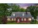 Charming brick home with a well-maintained lawn, mature trees and dormer windows at 407 E College E St, Bowdon, GA 30108